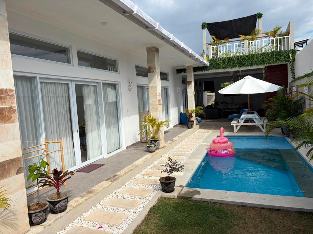 a house with a swimming pool in the yard at Villa Segara Agung Amed in Amed