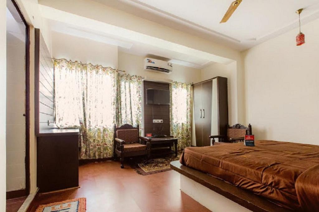 a bedroom with a bed and a desk and a chair at Hotel Holiday Home in Jaipur