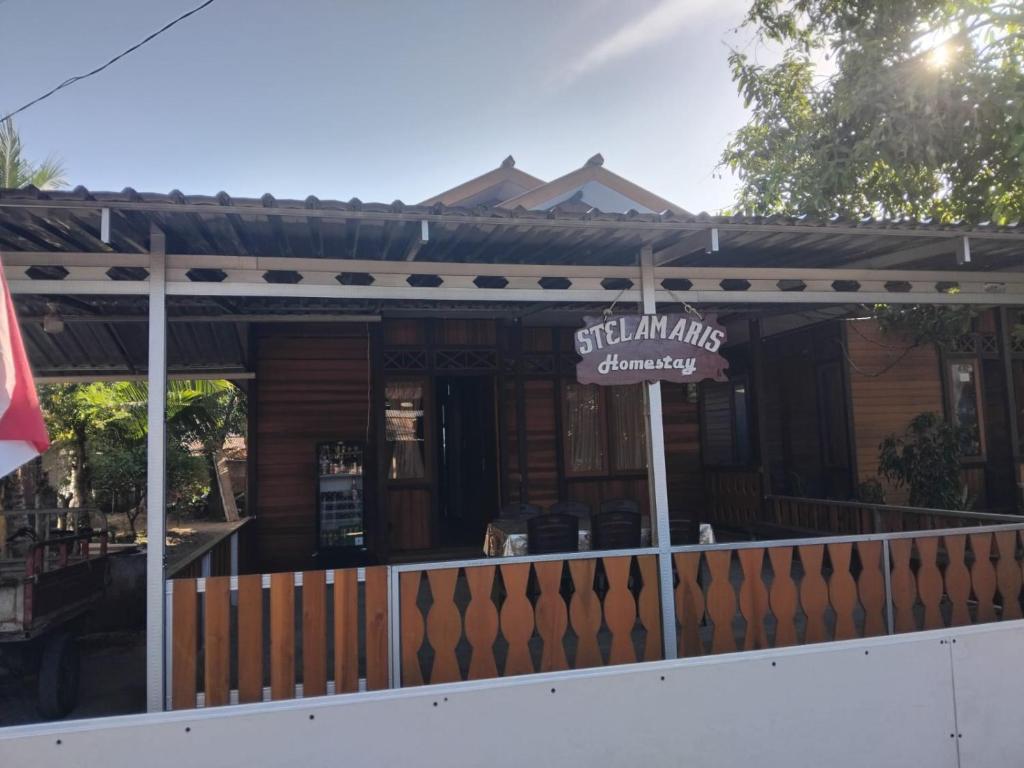 a house with a sign on the front of it at STELAMARIS HomeStay in Pulau Bunaken