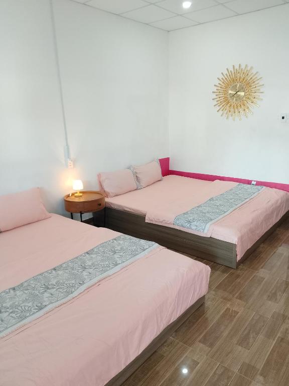 a room with two beds and a table at Hom Ba cây dừa in Vĩnh Hy