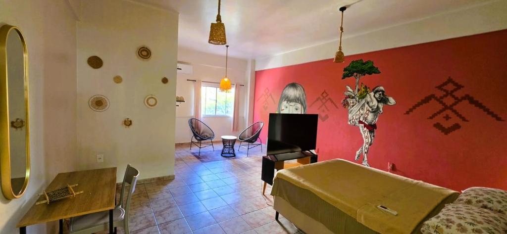 a living room with a couch and a red wall at Tribus Hostel in Manaus