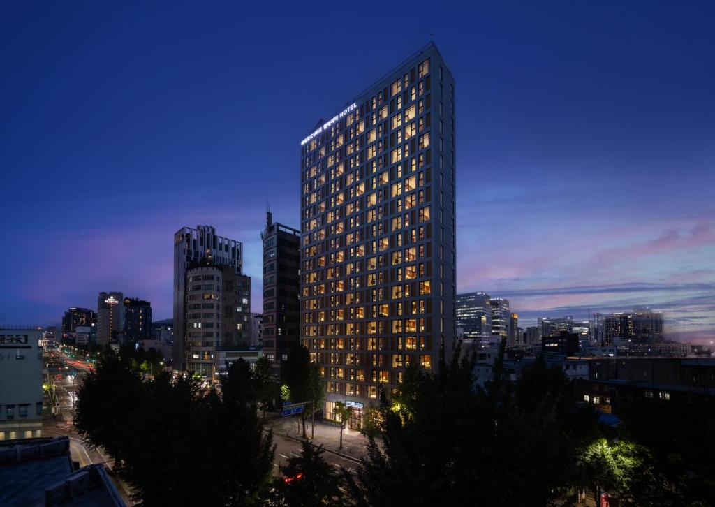 a tall building in a city at night at Mercure Ambassador Seoul Dongdaemun in Seoul