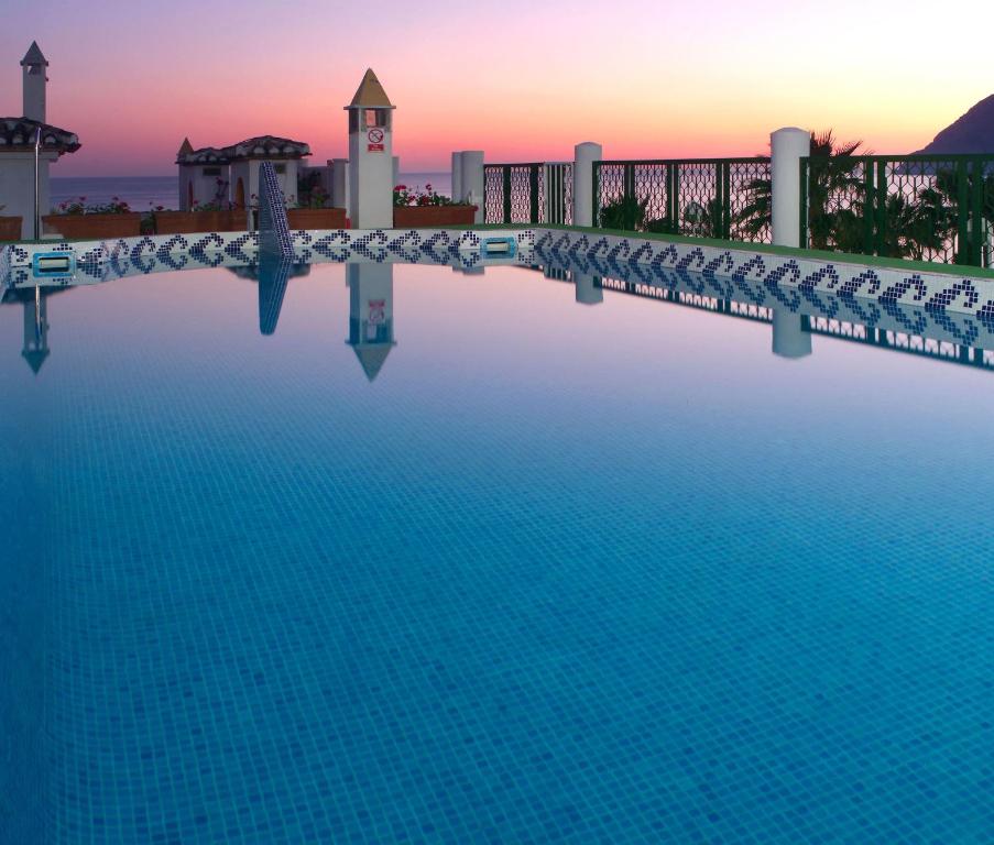 a view of a swimming pool at sunset at SOL by Meliá Los Fenicios in La Herradura