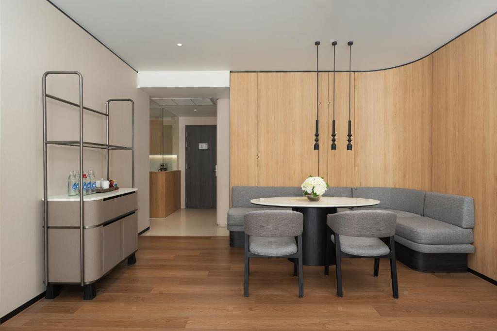 A compact dining nook with a curved banquette beside a service trolley and entry hall.