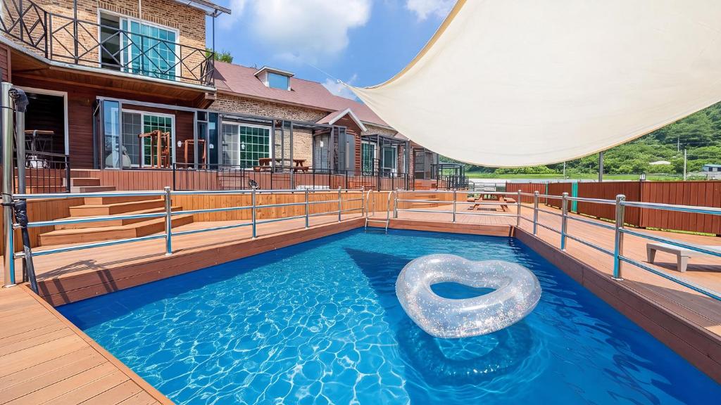 a pool with a raft in the middle of a house at Gapyeong Haneulsup Spa Pension in Gapyeong