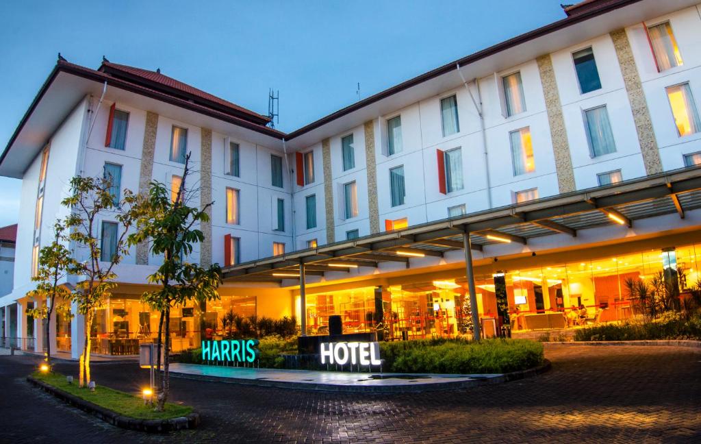 un edificio con un cartello hotel di fronte di HARRIS Hotel and Conventions Denpasar Bali a Denpasar