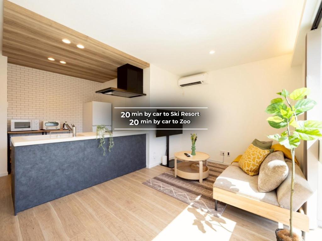 a living room with a couch and a kitchen at jeje asahikawa in Asahikawa