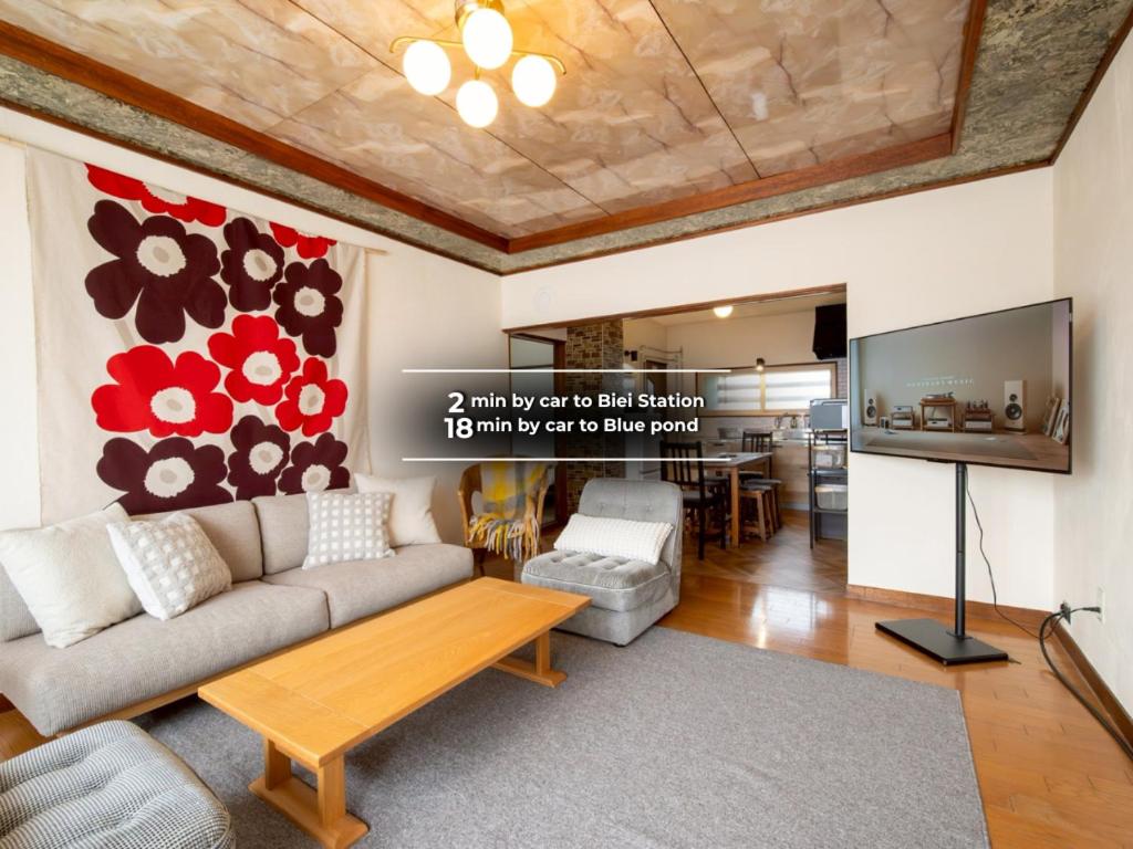 a living room with a couch and a tv at good day biei in Biei