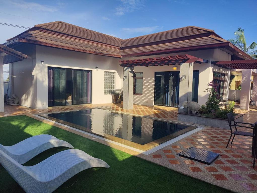 a house with a swimming pool in front of it at Nana's Bar & Hotel in Nong Prue