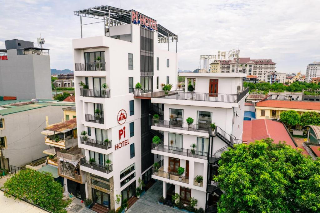 a white building with a sign on it at Pi Hotel Phố cổ Hoa Lư in Kỳ Vĩ
