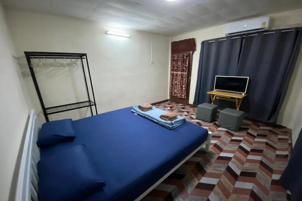 a room with a blue bed and a desk at Sleep Break Hostel Sathon in Bangkok