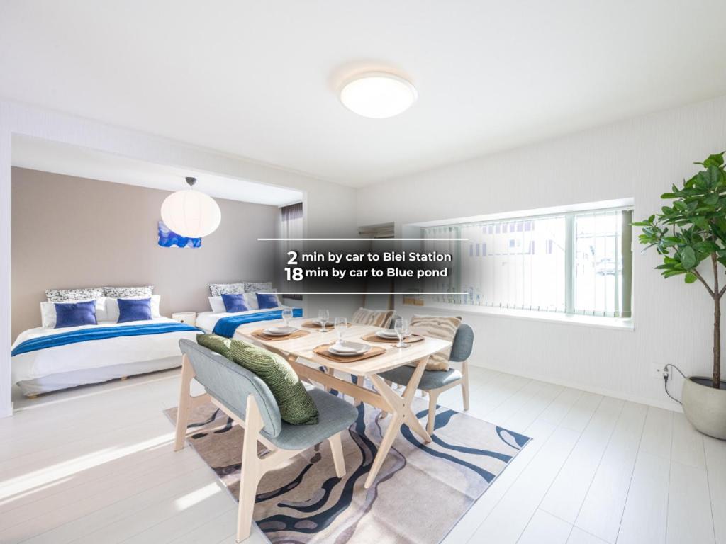 a living room with a table and chairs and a bed at BIEI BREEZE RESERVE Sui 水 in Biei