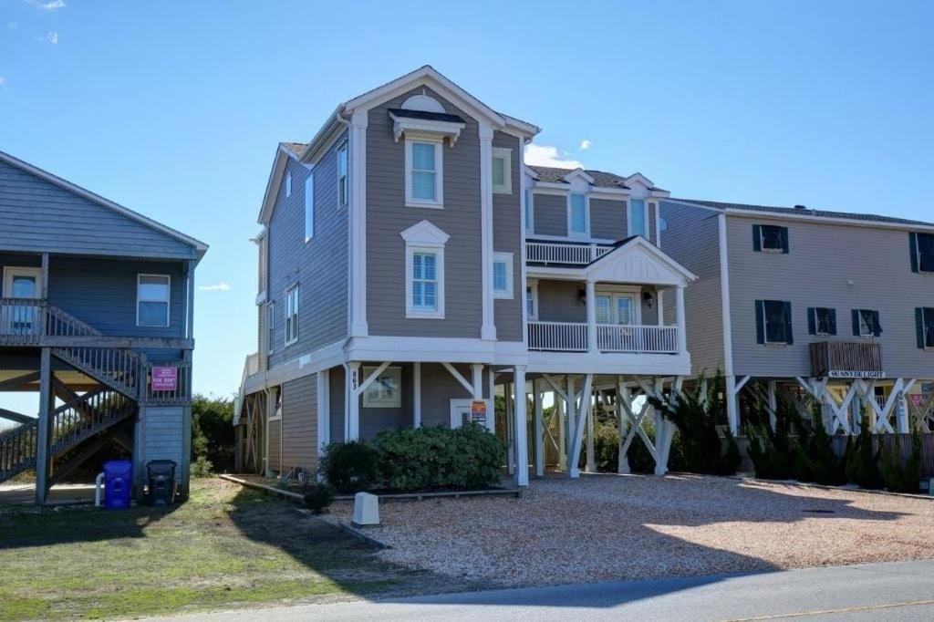 a row of houses on the side of a street at The Seventh Day in Holden Beach