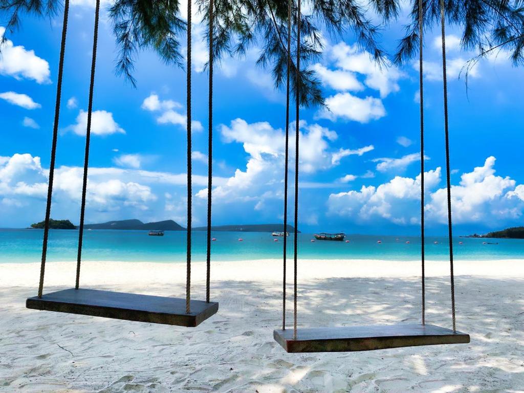 a swing on a beach with the ocean at Home Escape Resort in Phumĭ Bát Tráng (2)