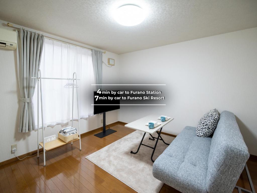 a living room with a couch and a table at Furano Ski Frante 2 in Furano