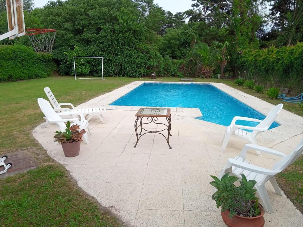a patio with two chairs and a table next to a pool at Quinta Un Sueño Junin in Junín