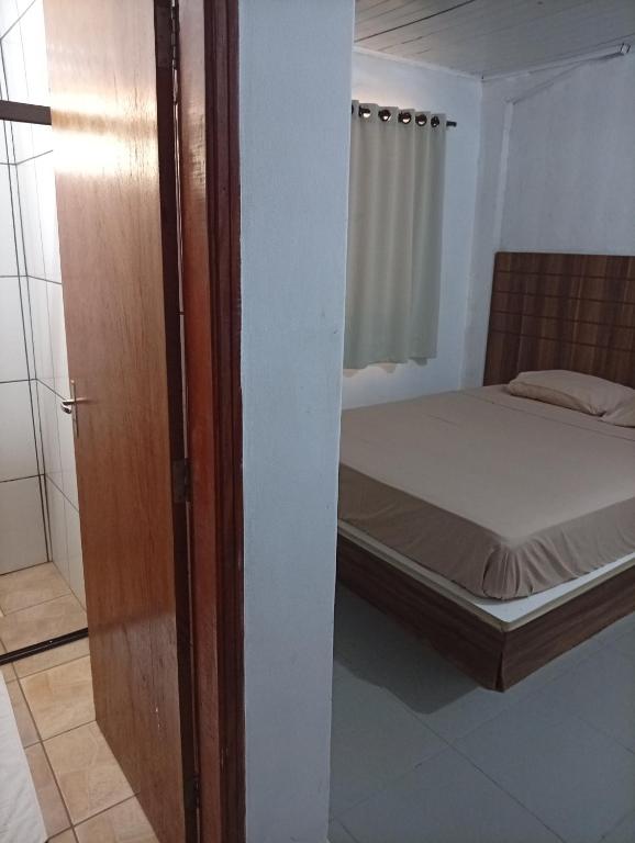 a bedroom with a bed and a sliding door at Hotel Central Cardinal Pedro Juan Caballero in Pedro Juan Caballero