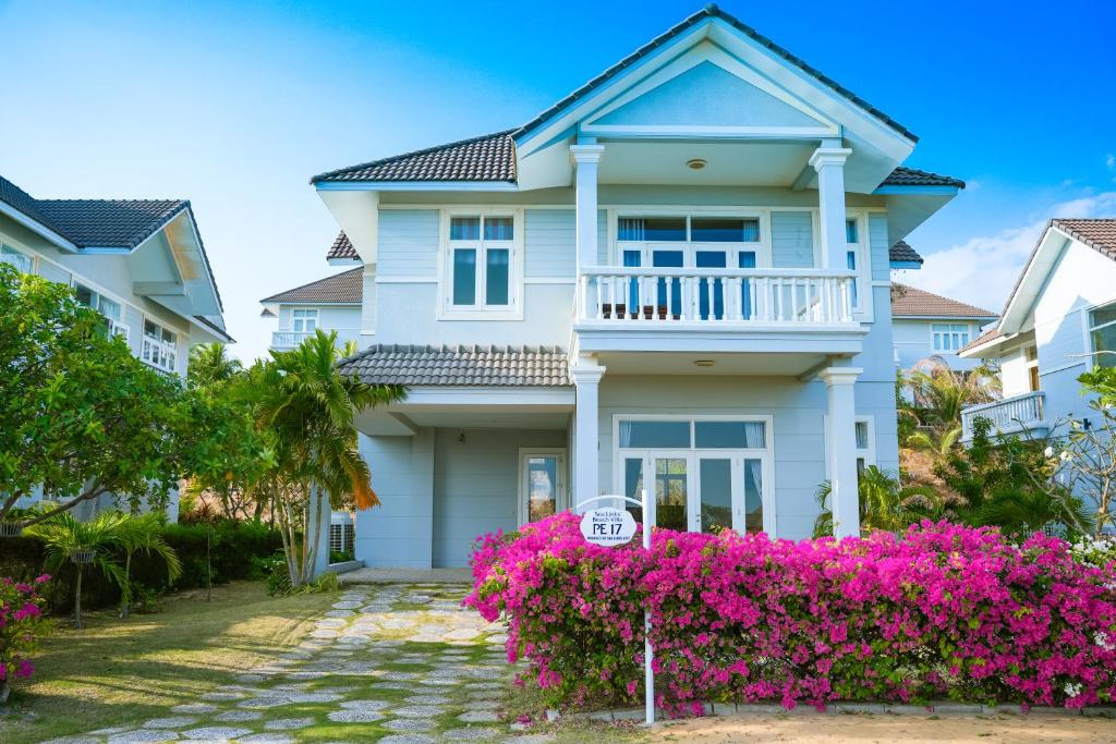 a house with pink flowers in front of it at Sea Links Beach Villa in Mui Ne