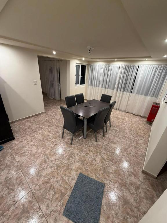 a dining room with a table and black chairs at La Cumbre in Chos Malal