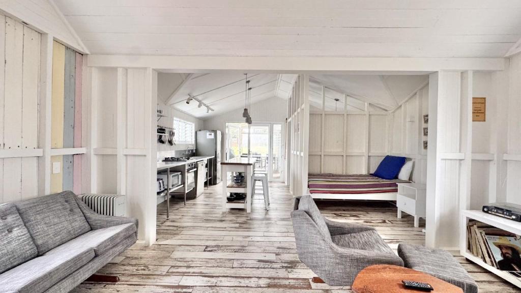 a living room with a couch and a kitchen at Jack s Cottage in Wooli