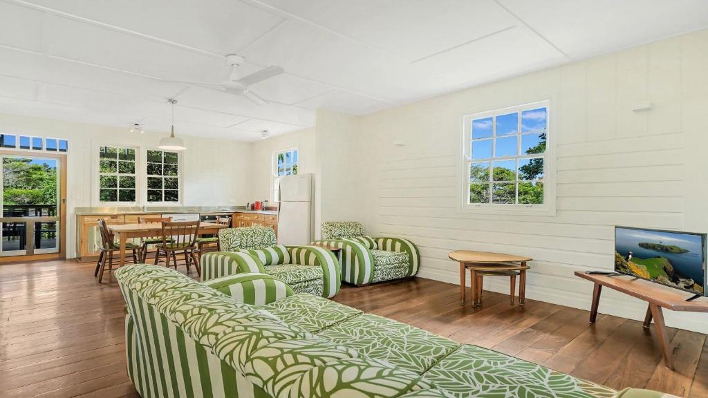 a living room with green and white chairs and a table at Moomba On Main in Wooli