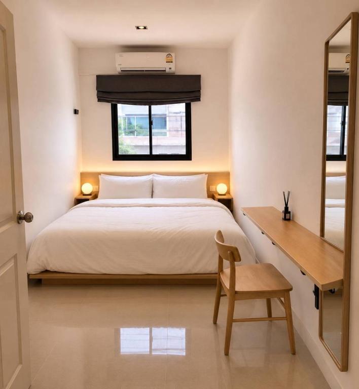 a bedroom with a bed and a desk and a window at 9 mins to BTS Private King share Bathroom Kitchen in Amphoe Phra Khanong