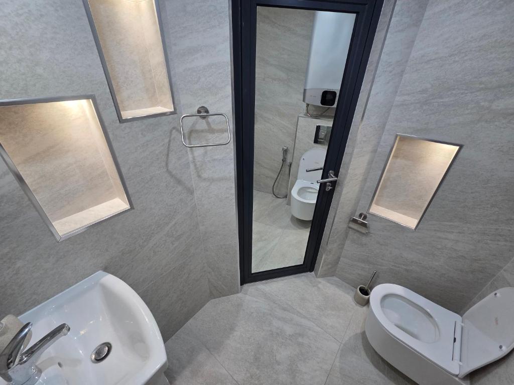 a bathroom with a sink and a toilet and a mirror at Fragma in Targovishte