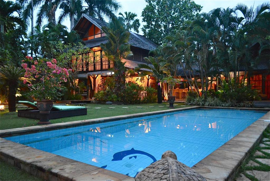 a swimming pool in front of a house at Villa Una in Seminyak