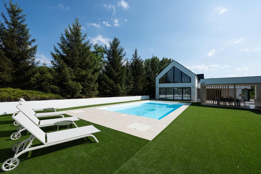 a backyard with a swimming pool and a house at Kálló Villa in Nagykálló