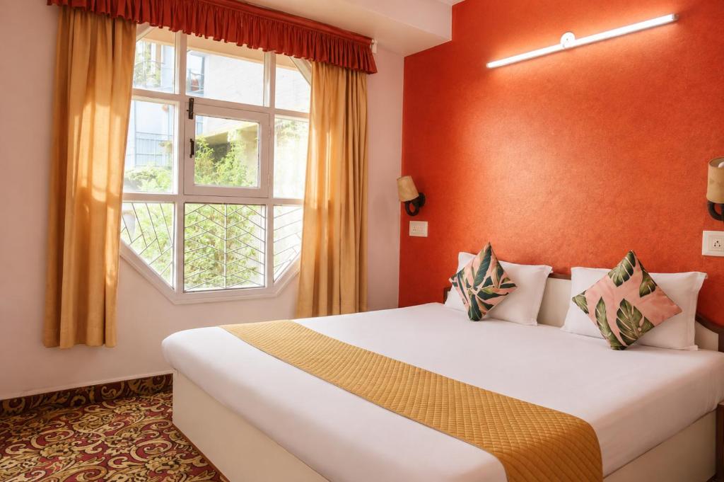 a bedroom with a bed and a window at The Boho Stays in Shimla