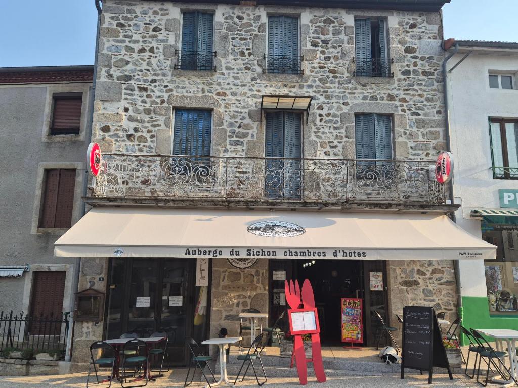 a store with tables and chairs in front of a building at Auberge du sichon in Ferrières-sur-Sichon