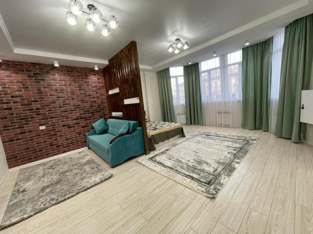 a living room with a blue chair and a brick wall at Asia Street in Bishkek