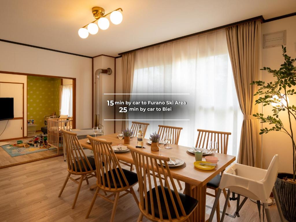 a dining room with a wooden table and chairs at FIKA - Komorebi in Furano