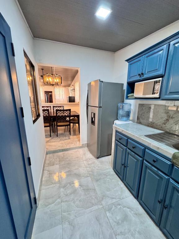 a kitchen with blue cabinets and a stainless steel refrigerator at Casa Dulce in Estelí