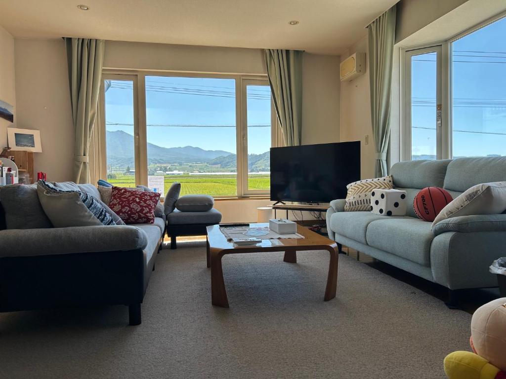 a living room with couches and a flat screen tv at countryside FURANO in Nakafurano