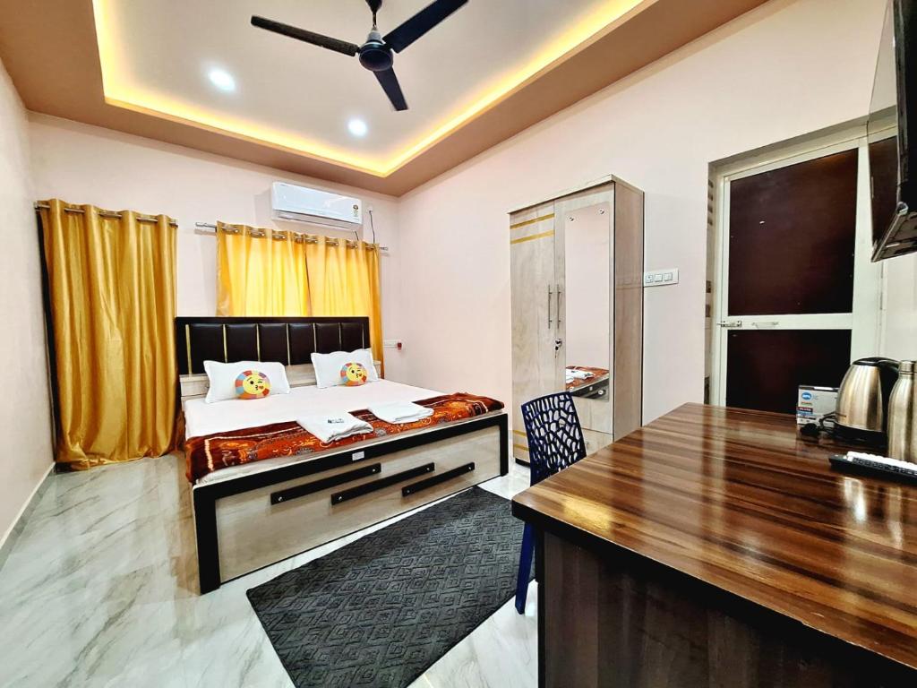 a bedroom with a bed and a desk in it at Mona Homestay in Sambalpur