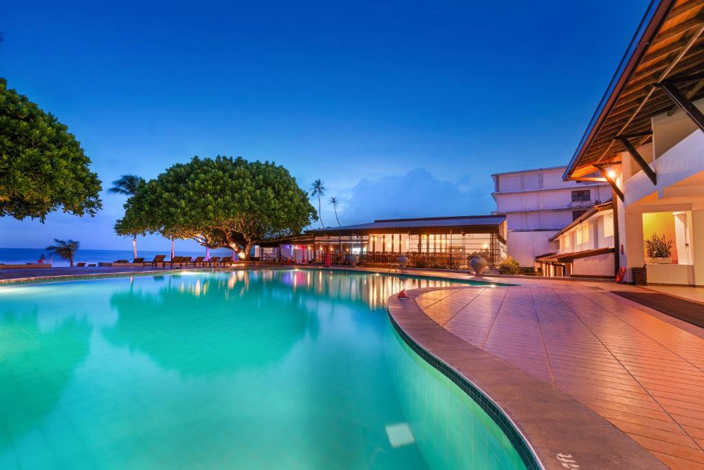 a swimming pool in front of a building at Citrus Hikkaduwa in Hikkaduwa