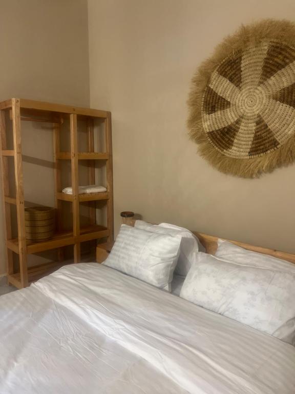 a bedroom with a bed with two pillows and a shelf at Garden Breeze in Bwejuu
