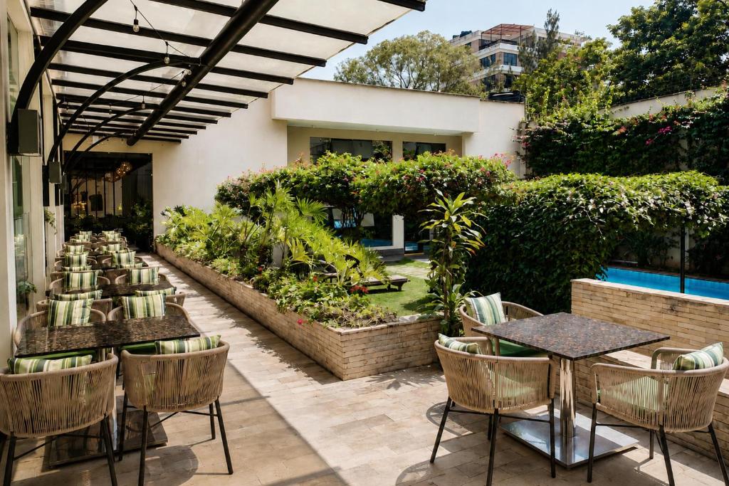 a patio with tables and chairs and a garden at DoubleTree by Hilton Nairobi in Nairobi
