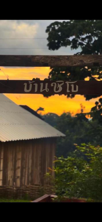a picture of a building with a sunset in the background at Chi Bo ดอยช้าง in Ban Huai Khai