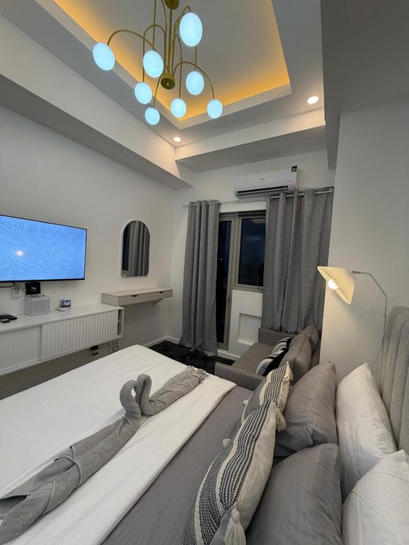 a living room with a large bed and a tv at Azzure North Pampanga Cloudline Suite 418 Barbados in San Fernando