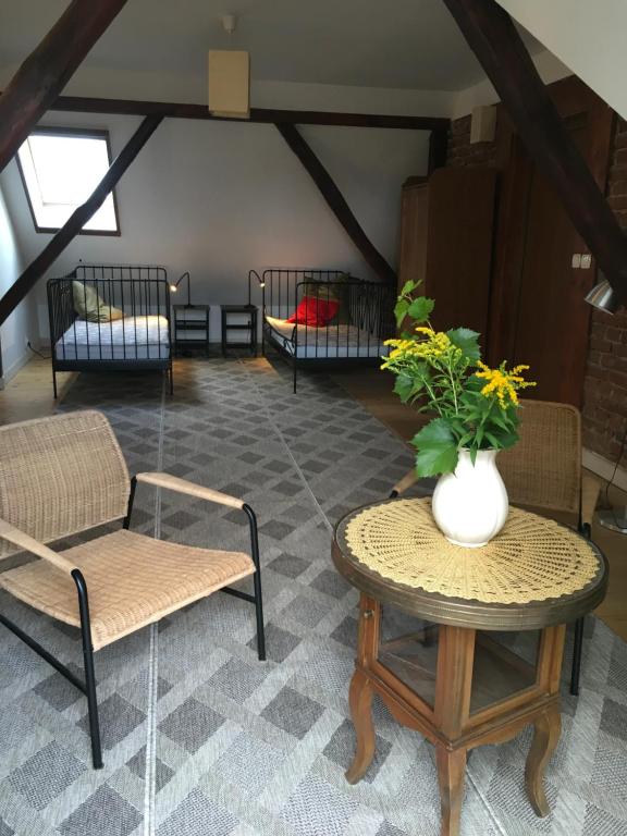 a living room with chairs and a table with a vase of flowers at Ku Wiśle 