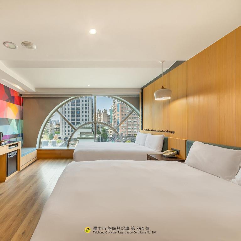 a hotel room with two beds and a large window at CHECK inn Taichung Wenxin Zhongqing in Taichung