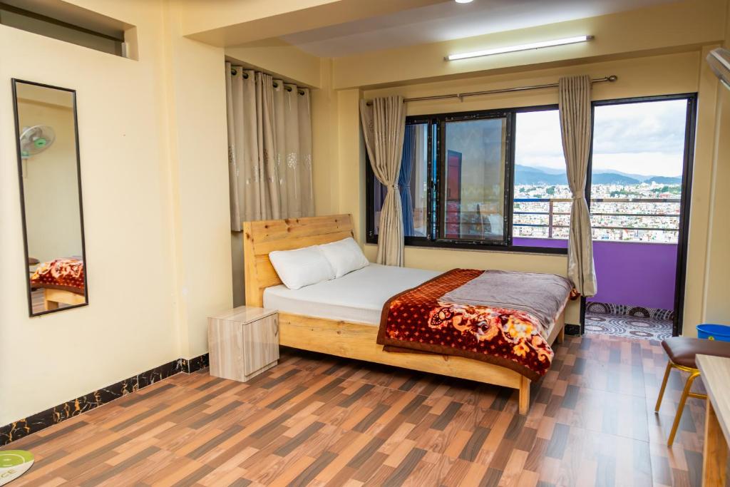 a bedroom with a bed and a large window at View point Restaurant and homestay in Kathmandu
