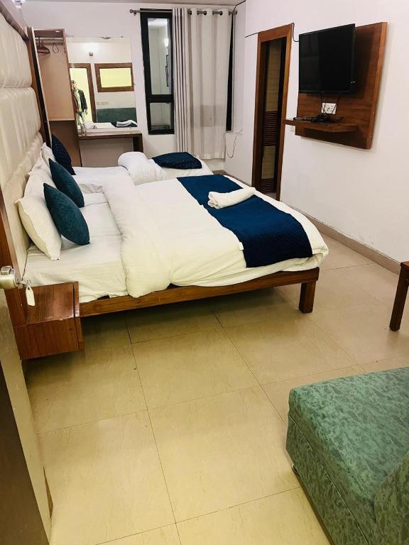 a bedroom with a large bed and a television at Hotel teara in Gwalior