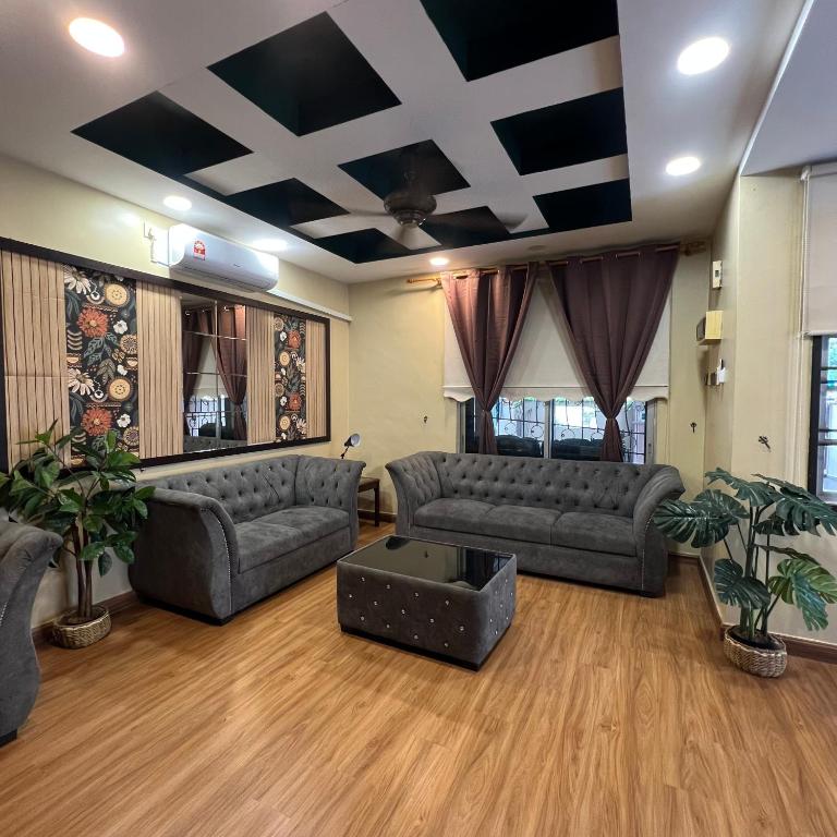 a living room with couches and a table at Homestay by Tas in Kulai