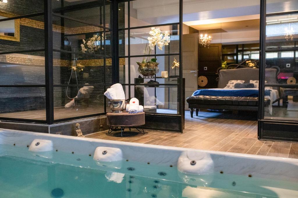 ein Hotelzimmer mit Swimmingpool und Schlafzimmer in der Unterkunft Suites Wellness à Sprimont - Logements avec jacuzzi pour 2 personnes in Sprimont