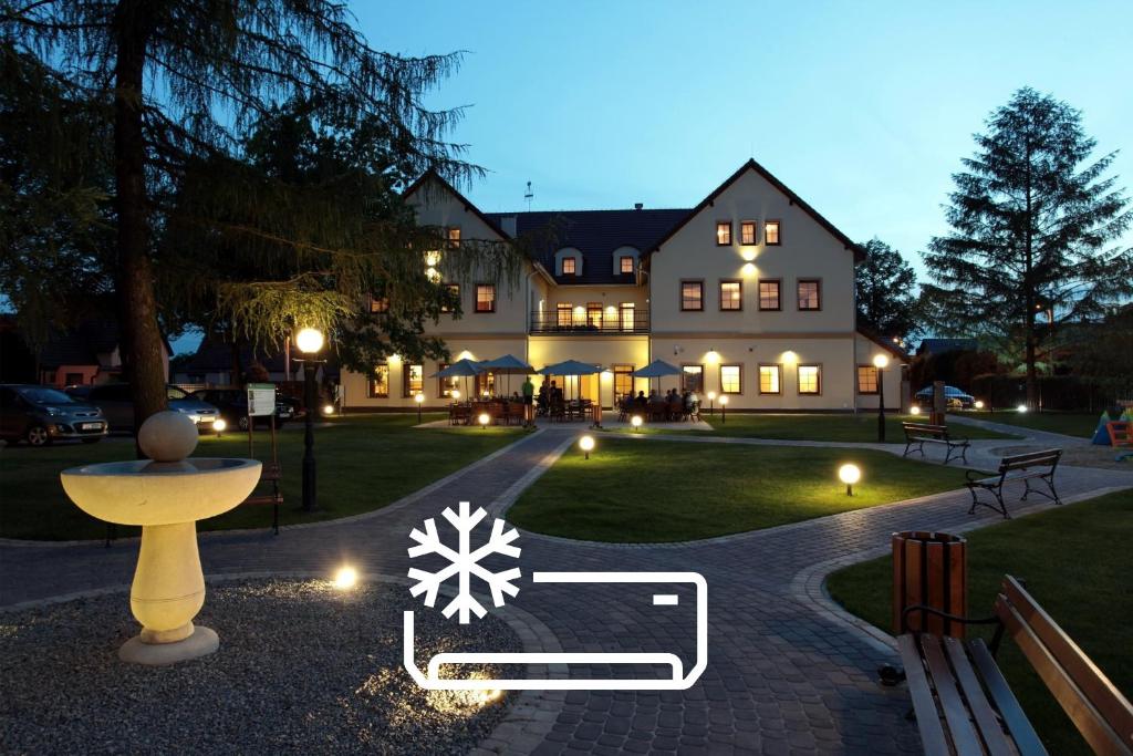 a large house with a snowflake on the lawn at Hotel Modrzewiowy Dwór in Gliwice