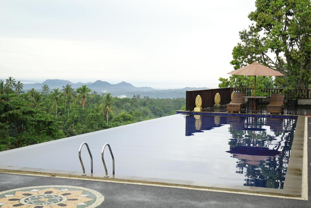 a pool at a resort with mountains in the background at Puri Karang Besakih in Menanga