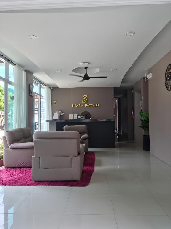 a living room with two couches and a pink rug at Sitara Patong Beach in Patong Beach